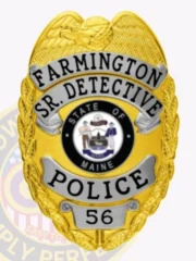 A custom metal badge gleaming in gold is presented here, featuring "FARMINGTON" and "SR. DETECTIVE" above a central emblem. The inclusion of silver panels and a safety pin attachment allows for easy and secure wear, making it suitable for professionals in law enforcement.