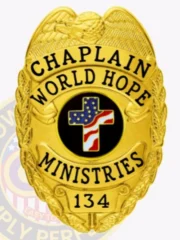 A striking custom metal badge in gold color with a safety pin attachment showcases the title "CHAPLAIN" and "WORLD HOPE MINISTRIES." The central emblem features a bold black circle with a decorative cross and the American flag, emphasizing its meaningful design.