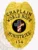 A striking custom metal badge in gold color with a safety pin attachment showcases the title "CHAPLAIN" and "WORLD HOPE MINISTRIES." The central emblem features a bold black circle with a decorative cross and the American flag, emphasizing its meaningful design.