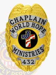 Featuring a custom metal badge in gold color with silver panels and a safety pin attachment, this badge highlights "CHAPLAIN" and "WORLD HOPE MINISTRIES." The central black circle is adorned with an eye-catching cross and patriotic colors, enhanced by shining silver elements.