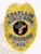 Featuring a custom metal badge in gold color with silver panels and a safety pin attachment, this badge highlights "CHAPLAIN" and "WORLD HOPE MINISTRIES." The central black circle is adorned with an eye-catching cross and patriotic colors, enhanced by shining silver elements.