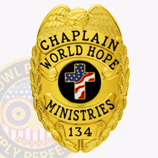 A custom metal badge in gold color with a safety pin attachment prominently displays the words "CHAPLAIN" and "WORLD HOPE MINISTRIES." The badge features a central black circle with a decorated cross and an American flag design, surrounded by intricate detailing.