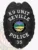 A striking custom metal badge in black with white lettering, shaped like a shield and featuring detailed engravings. The badge displays "K9 UNIT" at the top and "SEVILLE POLICE" below, both in bold white letters for high visibility. At the center, the state seal of Ohio is showcased, depicting a rising sun over a serene landscape within a circular black backdrop. The badge also includes the number "35" at the bottom. The matte finish of this custom metal badge in black with white lettering emphasizes its professional and authoritative presence, symbolizing the important role of K9 officers in law enforcement.