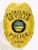 A gleaming custom metal badge in gold, featuring a shield shape with ornate detailing. The badge prominently displays "PATROLMAN SEVILLE" at the top and "POLICE" beneath it, both in bold black letters. In the center, the state seal of Ohio is depicted, showcasing a rising sun over a landscape within a circular black backdrop. The badge also includes the number "8810" at the bottom. The polished surface of this custom metal badge in gold enhances its elegance and authority, making it a distinguished symbol of law enforcement.