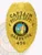 Oakbrook Police Department Captain gold eagle badge with raised eagle on top, black lettering surrounding the California state seal, “CAPTAIN POLICE DEPT. OAKBROOK” text and “456” identification number, attached by a safety pin.