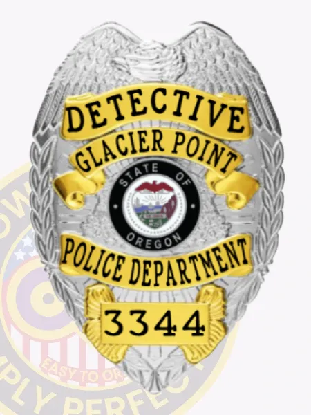 An eagle topped silver custom metal badge accented with gold panels, showcasing the title "DETECTIVE" at the top. The badge features "GLACIER POINT POLICE DEPARTMENT" and the Oregon state seal prominently in the center, along with the identification number "3344." It is equipped with a safety pin attachment for practical use.