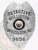 A custom metal badge glimmering in silver is presented here, showcasing "DETECTIVE" and the identification number "9856." The safety pin attachment allows for easy and secure wear, making it perfect for professionals looking to project authority effectively.