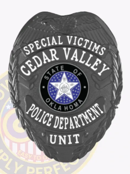 This image features a custom metal badge in black, prominently displaying "Special Victims Cedar Valley" along with "Police Department Unit." The badge includes a detailed Oklahoma state emblem and comes with a safety pin attachment for secure wearing.