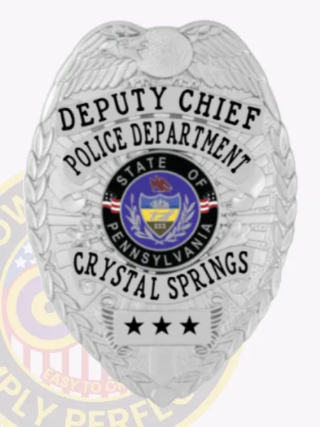This image features a custom metal badge in silver, prominently displaying "Deputy Chief Police Department" along with "Crystal Springs" and "PA." The badge includes a detailed Pennsylvania state emblem and comes with a safety pin attachment for secure wearing.