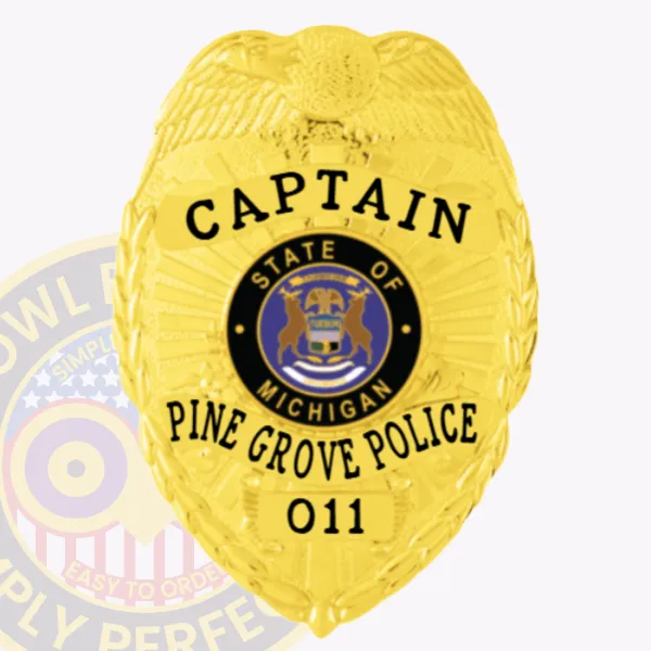 A vibrant image of a custom metal badge in silver with safety pin attachment, showcasing the title "CAPTAIN" prominently at the top. The badge features the state emblem of Michigan and the designation "PINE GROVE POLICE," along with the unique badge number 011, all set against a polished silver background.