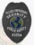 Stylish black metal badge showcasing the words "ALLIED UNIVERSAL SECURITY PUBLIC SAFETY" above a circular globe design. The safety pin attachment ensures it remains securely in place, making it ideal for uniform wear. This custom metal badge in black color with safety pin attachment reflects authority and vigilance in the security field.