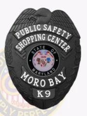 Featuring a custom metal badge in black color with a safety pin attachment, this badge emphasizes "PUBLIC SAFETY," "SHOPPING CENTER," and "K9." The centerpiece showcases a prominent circular emblem with the state seal, enhancing its authoritative appearance.