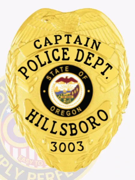 Gold metal badge for Hillsboro Police Captain displaying an eagle motif atop the shield, gold banners with bold black text reading "CAPTAIN," "POLICE DEPT.," and "HILLSBORO," surrounding the colorful Oregon state insignia, including badge number "3003" at the base and secured with a safety pin.