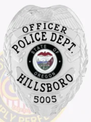 Silver metal badge for Hillsboro Police Officer displaying an eagle motif atop the shield, silver banners with bold black text reading "OFFICER," "POLICE DEPT.," and "HILLSBORO," surrounding the colorful Oregon state insignia, including badge number "5005" at the base and secured with a safety pin.