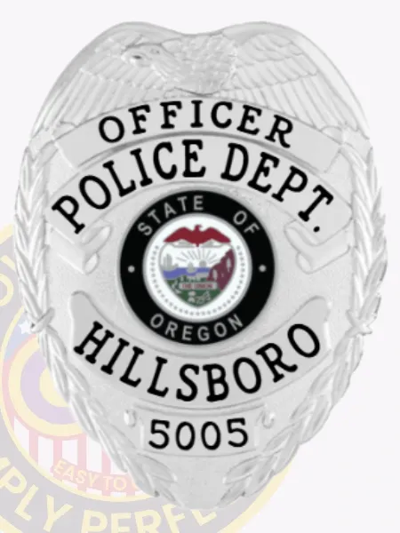 Silver metal badge for Hillsboro Police Officer displaying an eagle motif atop the shield, silver banners with bold black text reading "OFFICER," "POLICE DEPT.," and "HILLSBORO," surrounding the colorful Oregon state insignia, including badge number "5005" at the base and secured with a safety pin.