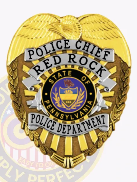 A custom metal badge in gold color is depicted here, prominently featuring "Police Chief Red Rock" on silver panels. The badge showcases an elegant Pennsylvania state emblem and includes a safety pin attachment for easy application on uniforms.