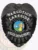 Matte black metal badge for Lakeside Police Narcotics featuring an eagle perched on top, white embossed text on black background reading "NARCOTICS," "LAKESIDE," and "POLICE DEPARTMENT," surrounding the official California state seal, finished with a safety pin attachment.