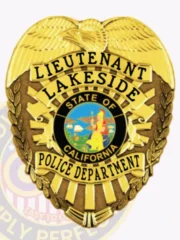 Gold metal badge for Lakeside Police Lieutenant displaying an eagle motif atop the shield, gold banners with bold black text reading "LIEUTENANT," "LAKESIDE," and "POLICE DEPARTMENT," surrounding the colorful California state insignia, finished with a safety pin for secure wear.