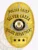 Gold custom oval metal badge for Silver Creek Police Chief displaying a central Colorado state seal, accented by gold banners with black text for "POLICE CHIEF," "SILVER CREEK," and "POLICE DEPARTMENT," and a bottom panel featuring three black stars, fastened with a safety pin.