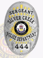 Detailed silver oval police badge for Silver Creek Sergeant featuring a Colorado state seal surrounded by gold rays, framed by silver banners labeled "SERGEANT," "SILVER CREEK," "POLICE DEPARTMENT," and the number "444," designed with a safety pin attachment.