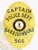 Oval-shaped custom gold metal badge for Harrisonburg Police Captain showing a raised Virginia state seal in the center, surrounded by gold banners with black text "CAPTAIN," "POLICE DEPT.," "HARRISONBURG," and badge number "566," held by a safety pin.