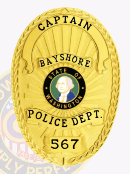 Custom gold oval police badge for Bayshore captain, finished in polished metal with a laurel wreath design framing the badge, black embossed words "CAPTAIN," "BAYSHORE," "POLICE DEPT.," and badge number "567," designed with a safety pin clasp on the back.