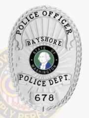 Oval silver metal badge customized for Bayshore Police Officer, featuring a textured laurel leaf border and a radiant background, black lettering reading "POLICE OFFICER," "BAYSHORE," "POLICE DEPT.," and identification number "678."