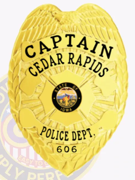 Shiny gold metal police badge designed for the Cedar Rapids police captain, showing a raised eagle perched at the top, bold black lettering CAPTAIN and CEDAR RAPIDS arched above a vibrant Iowa state emblem, POLICE DEPT. and badge number 606 engraved below, equipped with a safety pin fastener.