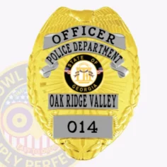 A vivid representation of a custom metal badge in gold with silver panels, designed for law enforcement. The badge reads "officer" and includes "police department," along with the state seal of georgia and the designation "oak ridge valley" with badge number 014. The safety pin attachment is highlighted for secure and convenient wear.