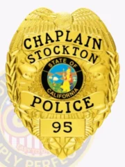 This custom metal badge in gold color with a safety pin attachment prominently displays "CHAPLAIN," "STOCKTON," and "POLICE." The badge features a vibrant central emblem showcasing the California state seal, surrounded by intricate golden detailing that signifies authority.