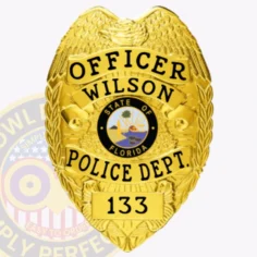 Gold metal badge for wilson police officer with an eagle figure crowning the badge, black bold text reading "officer wilson police dept. " and "133" on the lower plate, designed with a safety pin backing.