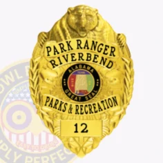 A custom metal badge in all gold, showcasing a detailed design with a prominent bear head at the top. The badge features "park ranger riverbend" in bold lettering, along with the alabama state seal in the center. Below the seal, the words "parks & recreation" are displayed, and the badge is numbered "12" at the bottom. This elegant design highlights the authority and craftsmanship of a custom metal badge in all gold.