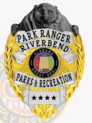 A custom metal badge featuring a gold base with intricately designed silver panels. At the top, a detailed bear head in black adds a striking element. The badge prominently displays "PARK RANGER RIVERBEND" and the seal of Alabama, surrounded by a decorative wreath design. This badge represents the Parks & Recreation department, showcasing its authority and connection to nature. Ideal for highlighting the craftsmanship of a custom metal badge with gold base, silver panels, and bear head in black.