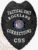 A custom metal badge in a sleek black color, shaped like a shield, representing the Tactical Unit of Rockland Corrections. The badge prominently features "TACTICAL UNIT" at the top, followed by "ROCKLAND" and "CORRECTIONS" in bold white letters. In the center, it showcases the state seal of Wisconsin, surrounded by decorative elements. The badge is labeled with the number "C55" at the bottom and includes a safety pin attachment on the back, allowing for secure wear by correctional officers, emphasizing its functional design and authority.