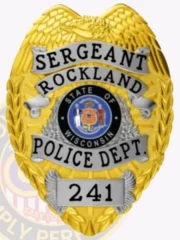 A striking custom metal badge in gold with silver panels, shaped like a shield and featuring intricate details. The badge prominently displays "SERGEANT ROCKLAND" at the top in bold black lettering. The center showcases the state seal of Wisconsin, encircled by a decorative silver border. Below this, “POLICE DEPT.” is written, and the badge features the number "241" at the bottom within a silver panel. The combination of the shiny gold finish and silver accents of this custom metal badge in gold with silver panels enhances its authority and professionalism, symbolizing pride in law enforcement.