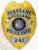 A striking custom metal badge in gold with silver panels, shaped like a shield and featuring intricate details. The badge prominently displays "SERGEANT ROCKLAND" at the top in bold black lettering. The center showcases the state seal of Wisconsin, encircled by a decorative silver border. Below this, “POLICE DEPT.” is written, and the badge features the number "241" at the bottom within a silver panel. The combination of the shiny gold finish and silver accents of this custom metal badge in gold with silver panels enhances its authority and professionalism, symbolizing pride in law enforcement.