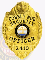 An intricate image of a custom metal badge in gold color with safety pin attachment, highlighting the "Cobbly Nob Security" lettering and the designation "SECURITY OFFICER." The badge's shiny surface and detailed decorations make it a striking symbol of authority.