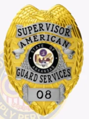 Custom metal badge in gold color with silver panels and with safety pin attachment, designed in a shield shape. The badge prominently features the word "SUPERVISOR" at the top, with "AMERICAN" below it. The center displays the state seal of Arkansas, surrounded by decorative elements. At the bottom, a silver panel shows the number "08," emphasizing its official designation.