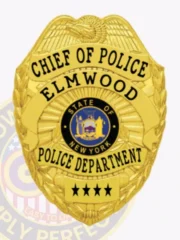 This uniquely custom metal badge shines in gold, showcasing "CHIEF OF POLICE" and "ELMWOOD." The center displays New York's emblem encircled by "POLICE DEPARTMENT." A practical safety pin attachment ensures easy application to uniforms.
