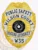 A custom metal badge with a gleaming gold finish and silver panels is showcased here, prominently displaying "PUBLIC SAFETY." The safety pin attachment ensures easy and secure wear, making it an excellent choice for law enforcement officers who need to exhibit their credentials confidently.