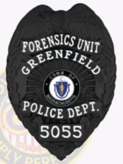 Greenfield Police Forensics Unit custom black metal badge, showing a detailed eagle with wings spread at the top, bold white lettering around the Massachusetts emblem, labeled “FORENSICS UNIT” and numbered “5055,” attached with a safety pin.