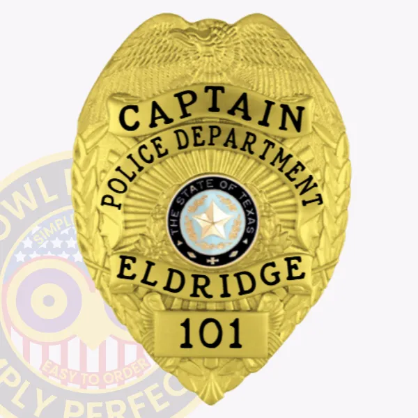 Custom gold metal badge for Eldridge Police Captain featuring a raised eagle crest at the top, bold black text around the Texas state seal reading "CAPTAIN POLICE DEPARTMENT ELDRIDGE," with badge number "101" on a gold plate at the bottom and secured by a safety pin.