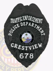 Crestview Police Department Traffic Enforcement black eagle badge with raised eagle on top, white bold lettering surrounding the Florida state seal, “TRAFFIC ENFORCEMENT POLICE DEPARTMENT CRESTVIEW” text and “678” identification number, attached by a safety pin.