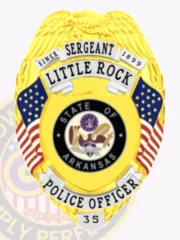 A distinguished custom metal badge gold with silver panels, shaped like a shield and featuring intricate detailing. The badge displays "SERGEANT" at the top, followed by "LITTLE ROCK" and "SINCE 1899" in bold letters. In the center, the state seal of Arkansas is shown within a circular design, surrounded by two small American flags. Below the seal, "POLICE OFFICER" is clearly inscribed, and the number "35" is displayed at the bottom on a silver panel. The combination of shiny gold and silver accents on this custom metal badge gold with silver panels enhances its authority and professionalism, symbolizing pride in law enforcement.