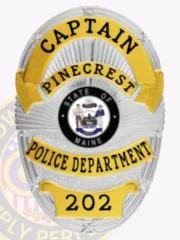 Silver custom oval metal badge for Pinecrest Police captain, featuring a radiant sunray background, gold banners with black text for "CAPTAIN," "PINECREST," "POLICE DEPARTMENT," and badge number "202," with the State of Maine seal prominently positioned and safety pin attachment on back.