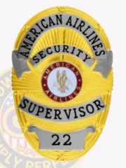 Striking gold badge adorned with sophisticated silver panels, showcasing the inscription "AMERICAN AIRLINES SECURITY SUPERVISOR." The badge includes a central emblem representing the airline and features a safety pin attachment for practical wear. This custom metal badge in gold color with silver panels and safety pin attachment represents dedication and leadership in the security field.
