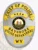 This custom metal badge in silver features a classic oval shape with elegant gold accents. The title "CHIEF OF POLICE" is prominently displayed at the top in bold black letters. Below, the badge showcases the emblem of the Bayshore Police Department at the center, encircled by "STATE OF WEST VIRGINIA." The bottom section reads "BAYSHORE POLICE DEPARTMENT" and "WV," ensuring clear visibility. A safety pin attachment allows for secure wearing.