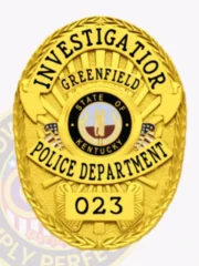 This custom metal badge in gold features a striking oval shape with intricate detailing. The title "INVESTIGATOR" is prominently displayed at the top in bold black lettering. Below it, "GREENFIELD" is featured, while the center showcases the emblem of the Greenfield Police Department, encircled by "STATE OF KENTUCKY." The bottom section reads "POLICE DEPARTMENT" and the badge number "023." A safety pin attachment ensures secure wearing.
