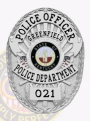 An elegant custom metal badge in silver presents a traditional oval design with detailed engravings. The words "POLICE OFFICER" are prominently displayed at the top in striking black font. The center features the Greenfield Police Department insignia, framed by "STATE OF KENTUCKY." The lower part includes "POLICE DEPARTMENT" and "021," all in clear black text. A safety pin attachment allows for convenient wear.