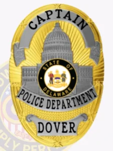 Custom dover police captain badge in gold and silver tones with a prominent capitol building and delaware seal in the middle, marked with "captain" at the top, "police department" across the center, and "dover" on a banner below, attached via safety pin.